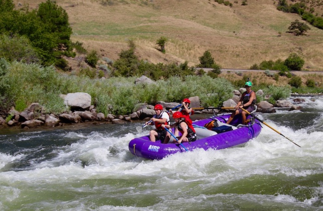 Family in a raft with a guide in whitewater in Idaho
