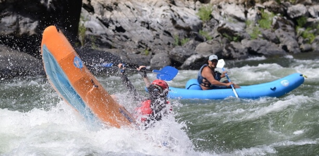 Inflatable kayaker going through a large wave on the single day section of the Rogue River.
