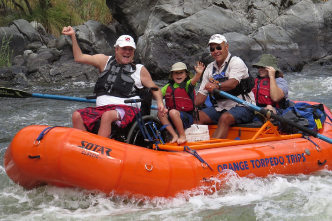 Man in wheel chair with his family on the Rogue river