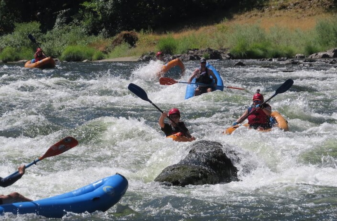 Orange Torpedo kayakers going through Argo rapid on the Rogue River