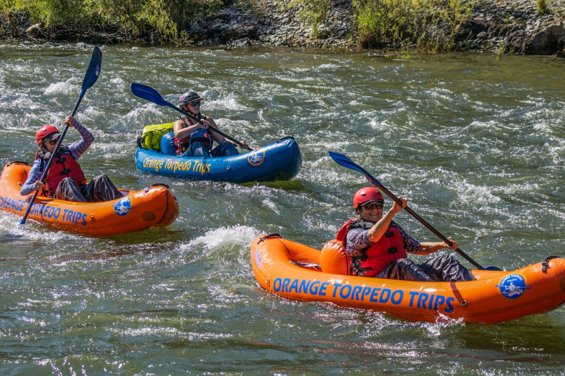 A few women and a female guide paddling down the Rogue River